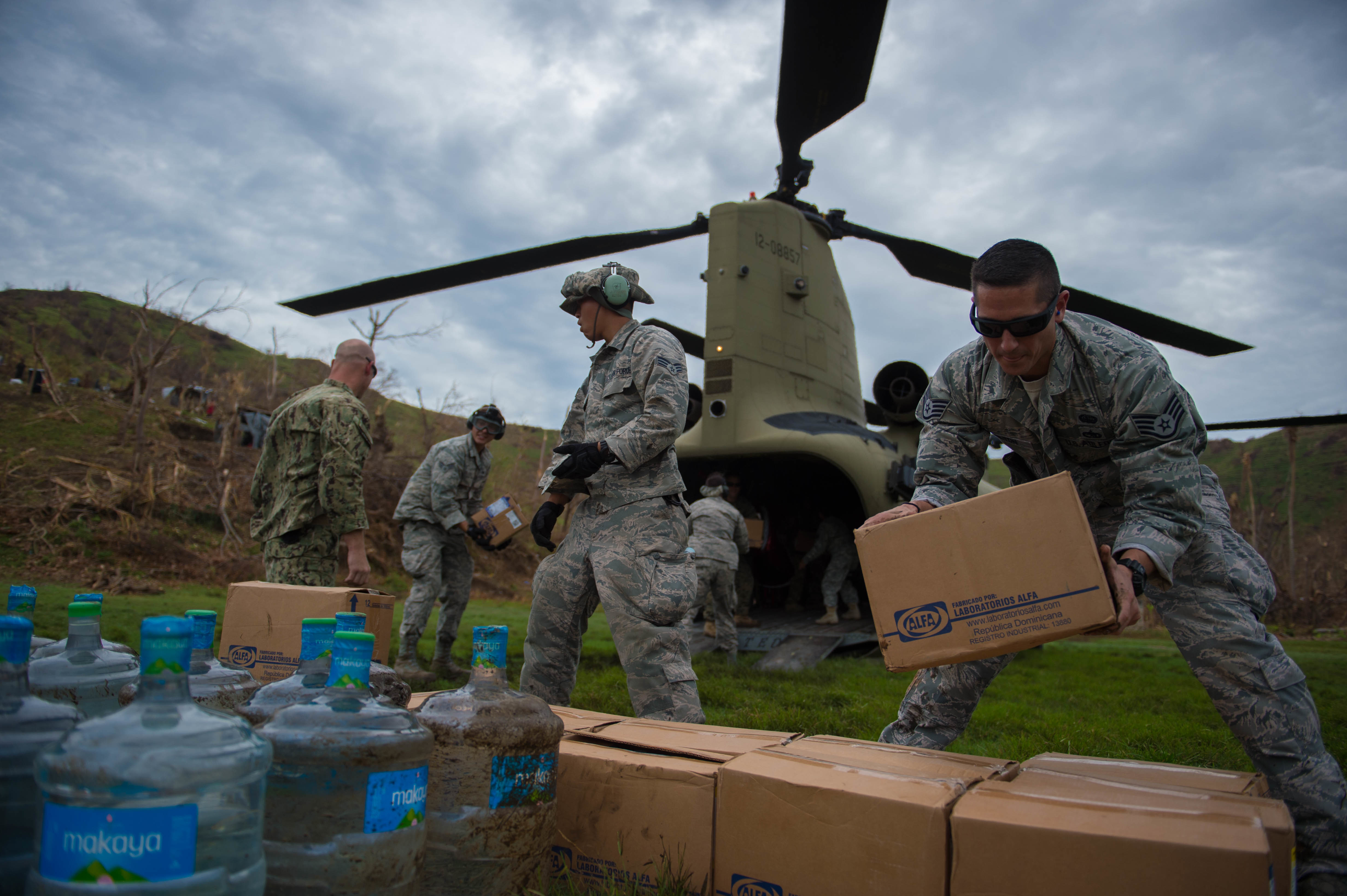 U.S. service members stack boxes of aid which and water while off loading a U.S. Army CH-47 Chinook during an aid relief mission Oct. 14, 2016 in Anse d'Hainault, Haiti. 